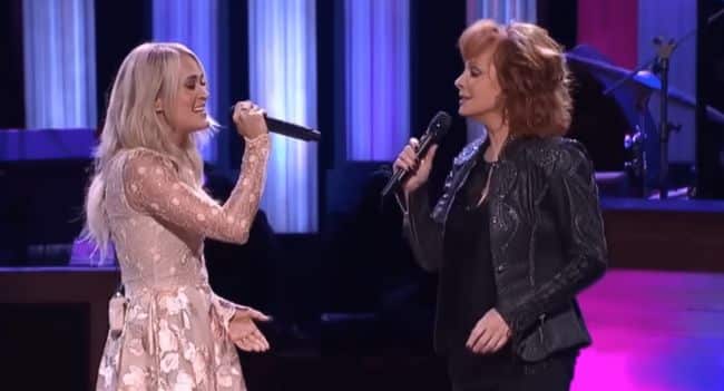 Reba Tears Up the Grand Ole Opry, Dolly and Carrie Crash the Stage, and Their Epic Does He Love You Duet Sends Country Fans Into a Frenzy